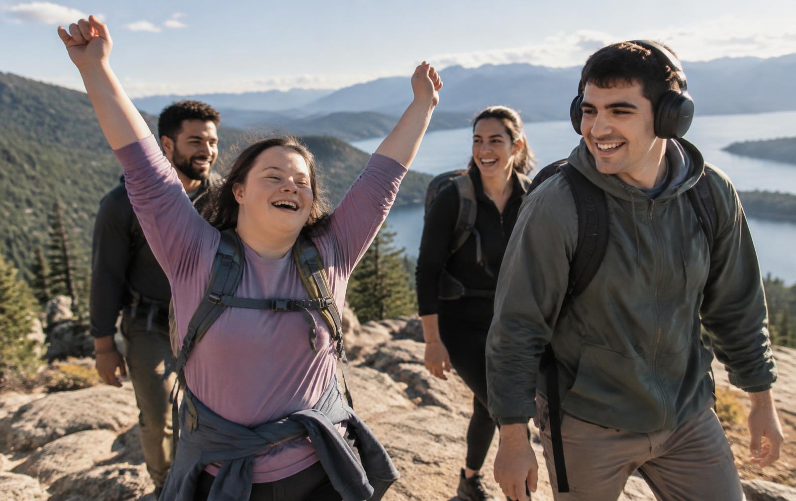 A group of young adults celebrating together on a mountain overlook while hiking